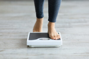 Picture of a woman stepping onto a scale.