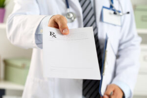 Picture of a doctor holding a prescription pad.