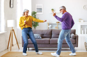 Picture of an older man and woman dancing in a living room.