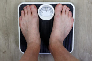 Picture of a man's feet as he stands on a scale.