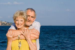 Senior couple posing for the camera on a beach