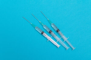 Picture of two syringes and three clear vials.