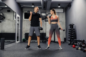 Man and woman exercising together in a gym